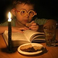 Ребёнок со свечёй и хлебом перед книгой